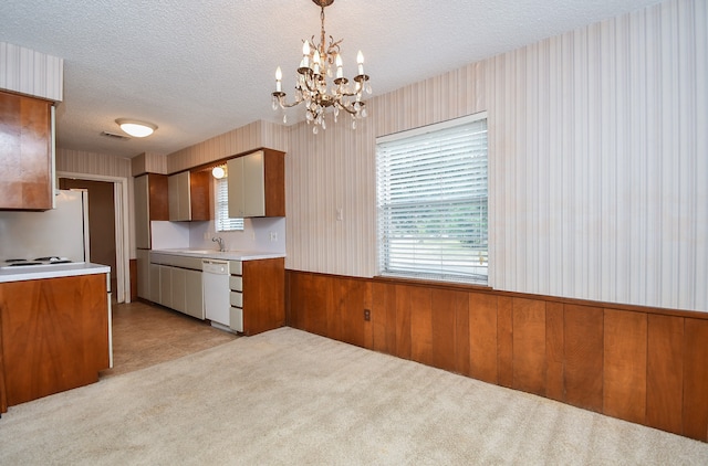 kitchen with light carpet, hanging light fixtures, an inviting chandelier, a textured ceiling, and white appliances