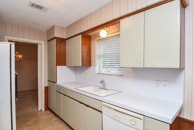 8218 Hazen St, Houston, TX 77036 - kitchen with white appliances, a sink, light countertops, a textured ceiling, and wallpapered walls