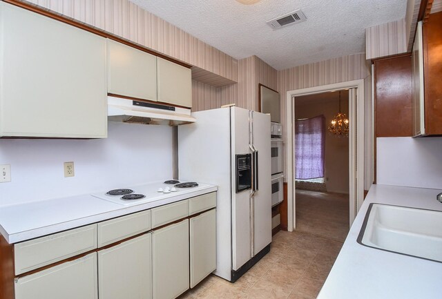 8218 Hazen St, Houston, TX 77036 - kitchen featuring under cabinet range hood, light countertops, white appliances, and a textured ceiling