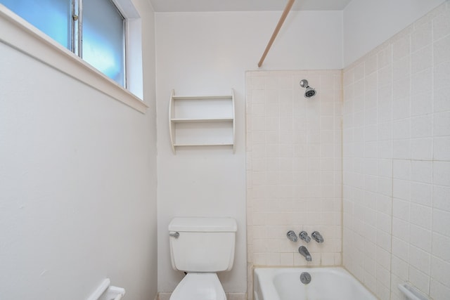 bathroom with toilet and tiled shower / bath