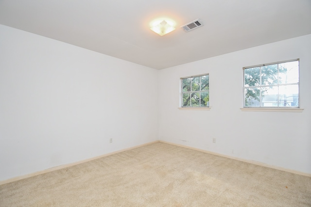 unfurnished room featuring light carpet