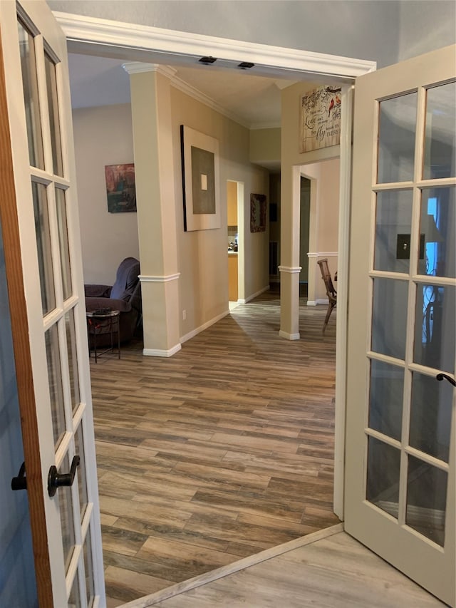 hall with french doors, crown molding, and hardwood / wood-style flooring