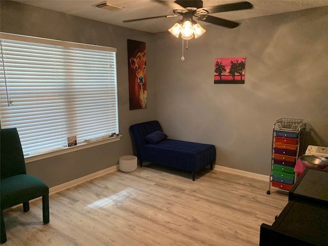 living area featuring hardwood / wood-style floors and ceiling fan