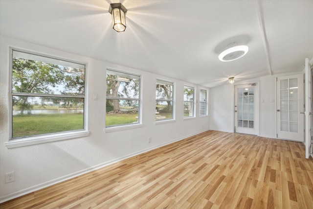 unfurnished sunroom with a water view