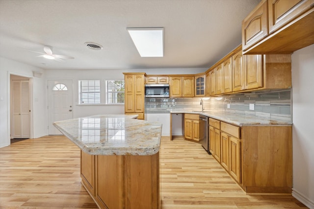 kitchen with stainless steel appliances, a center island, visible vents, and light wood-style flooring