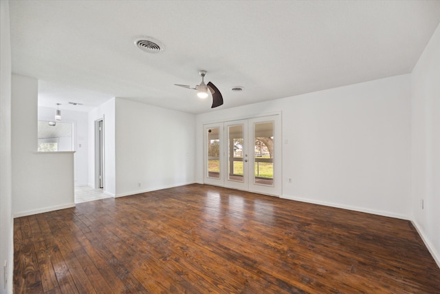 empty room with french doors, visible vents, a ceiling fan, baseboards, and hardwood / wood-style flooring