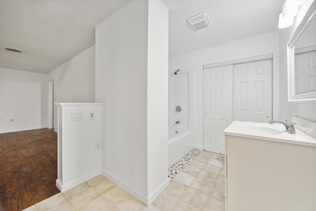 bathroom featuring washtub / shower combination, visible vents, vanity, and baseboards