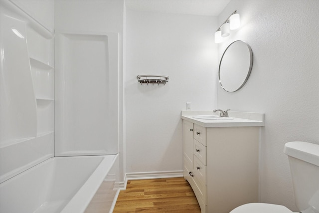 bathroom with shower / bathtub combination, vanity, wood finished floors, and toilet