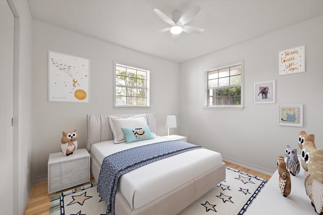 bedroom featuring light wood-type flooring, baseboards, and a ceiling fan