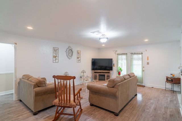 living room featuring light hardwood / wood-style floors and crown molding