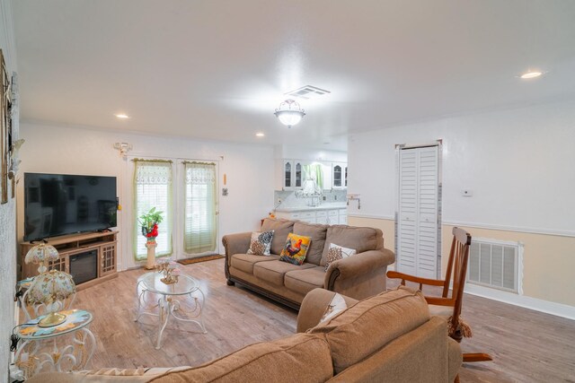 living room featuring ornamental molding and light wood-type flooring