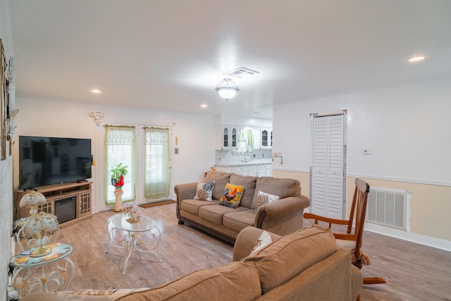 living area featuring recessed lighting, visible vents, baseboards, and wood finished floors