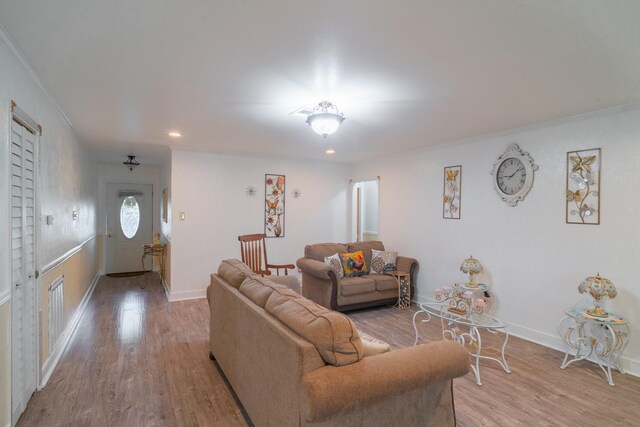 living room with ornamental molding and light wood-type flooring