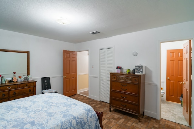 bedroom with a textured ceiling and a closet