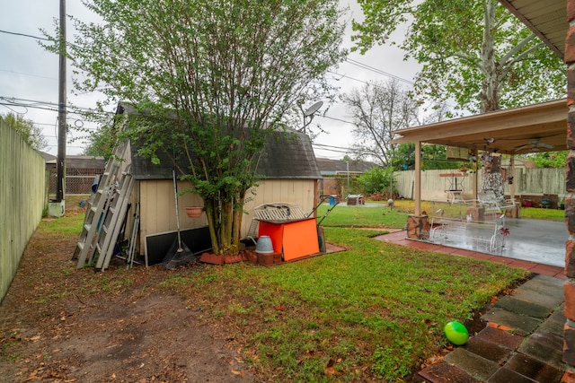 view of yard with a patio area, a storage unit, and ceiling fan