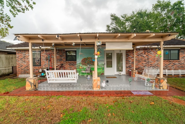 rear view of property featuring a patio and a lawn