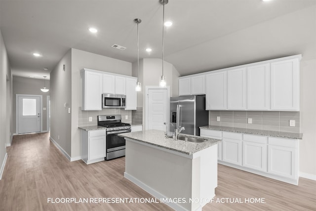 kitchen with light hardwood / wood-style floors, decorative light fixtures, white cabinets, and stainless steel appliances