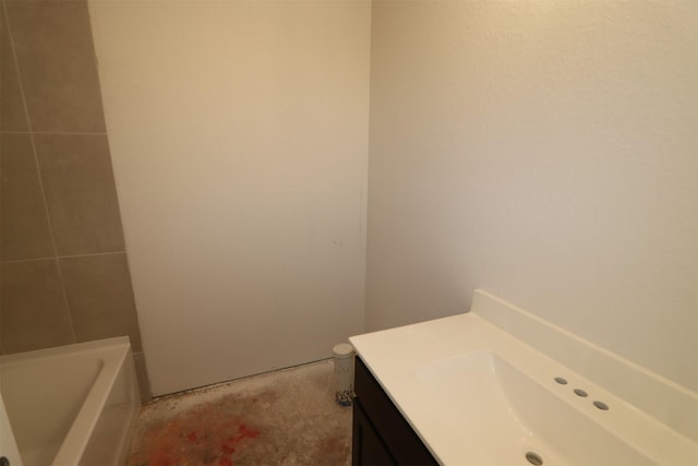 full bath featuring unfinished concrete floors, vanity, and a tub