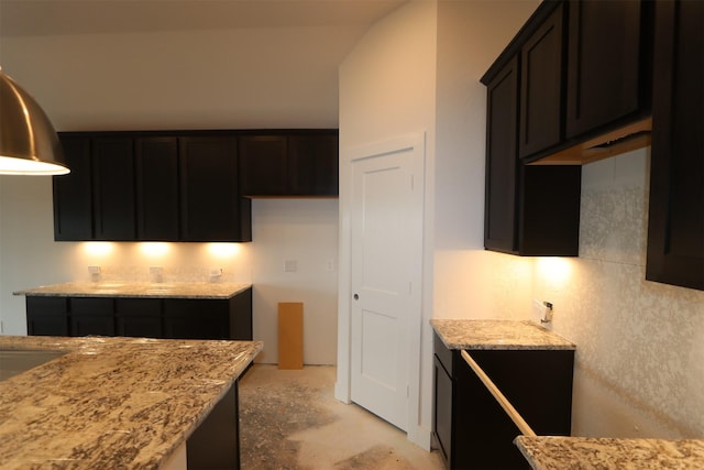 kitchen with light stone counters and unfinished concrete flooring