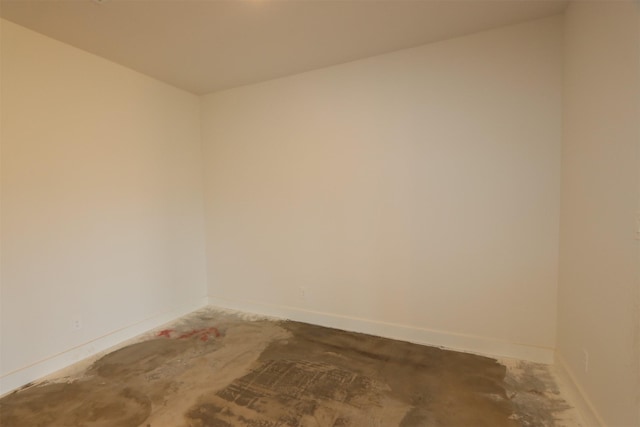 empty room with baseboards and concrete floors