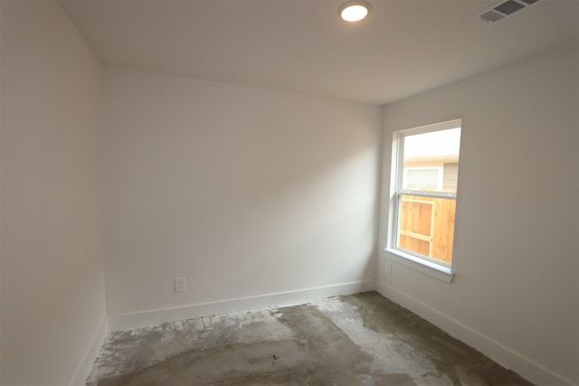 unfurnished room featuring unfinished concrete floors, visible vents, and baseboards