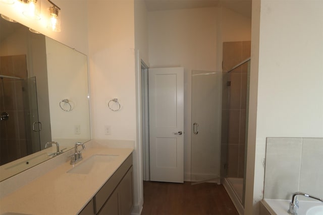 bathroom featuring walk in shower, vanity, and hardwood / wood-style floors