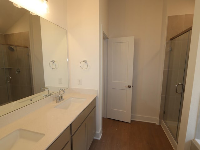 bathroom featuring a sink, wood finished floors, and a stall shower