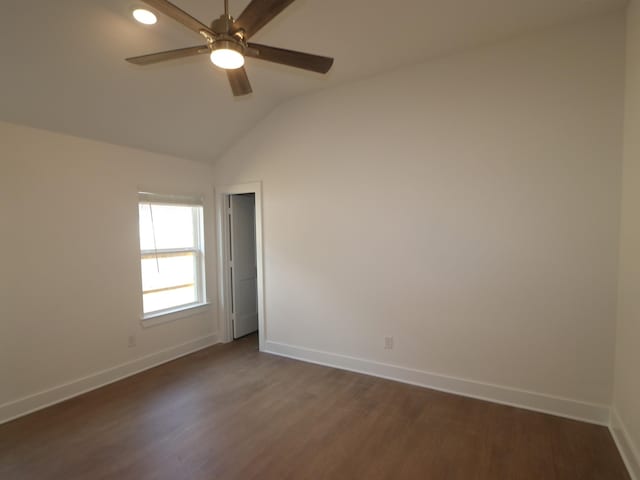 spare room featuring baseboards, a ceiling fan, lofted ceiling, and dark wood-style flooring