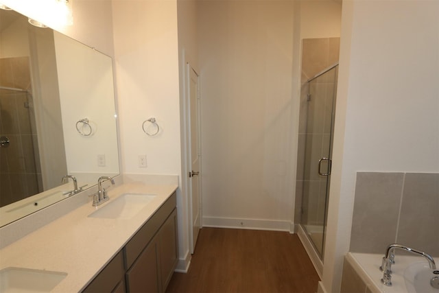 full bathroom featuring a sink, wood finished floors, and a shower stall