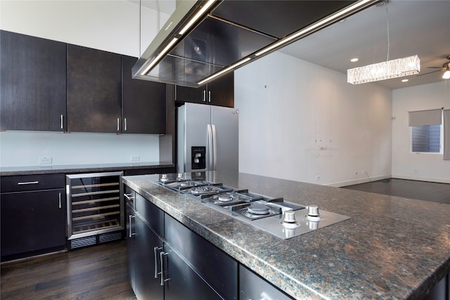 kitchen with beverage cooler, ceiling fan, appliances with stainless steel finishes, dark hardwood / wood-style floors, and a center island