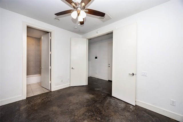 unfurnished bedroom with ceiling fan, ensuite bath, and concrete floors