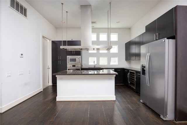 kitchen featuring dark wood-type flooring, stainless steel appliances, a center island, and pendant lighting