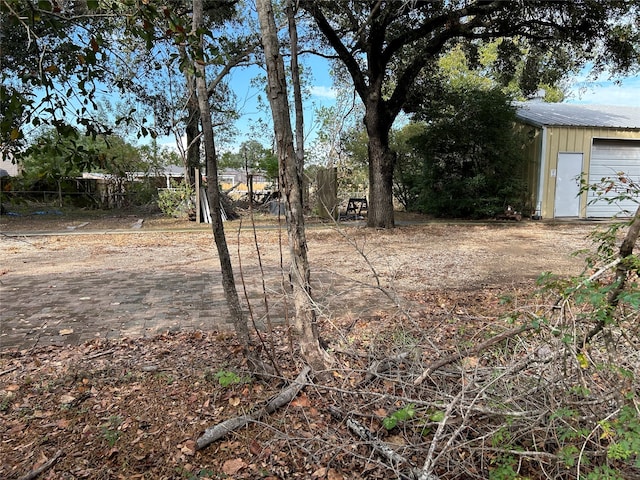 view of yard featuring a garage and an outbuilding