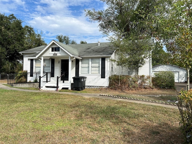 view of front of house with an outdoor structure, a garage, a front lawn, and a porch