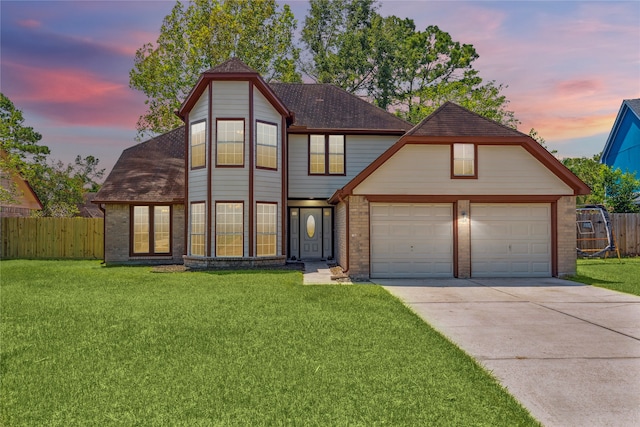 view of front of property with a garage and a lawn