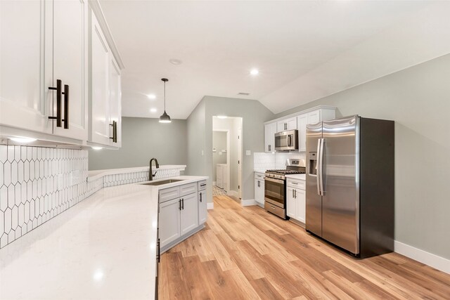 kitchen with white cabinets, light wood-type flooring, stainless steel appliances, sink, and decorative light fixtures