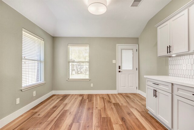 interior space with light hardwood / wood-style floors and lofted ceiling