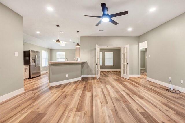 unfurnished living room with french doors, sink, light wood-type flooring, and ceiling fan