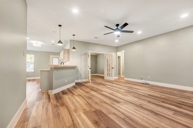 unfurnished living room featuring light wood-type flooring and ceiling fan