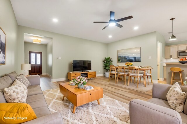 living room with light wood-type flooring and ceiling fan