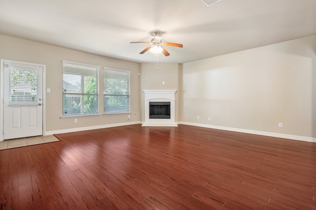 unfurnished living room with ceiling fan and dark hardwood / wood-style flooring