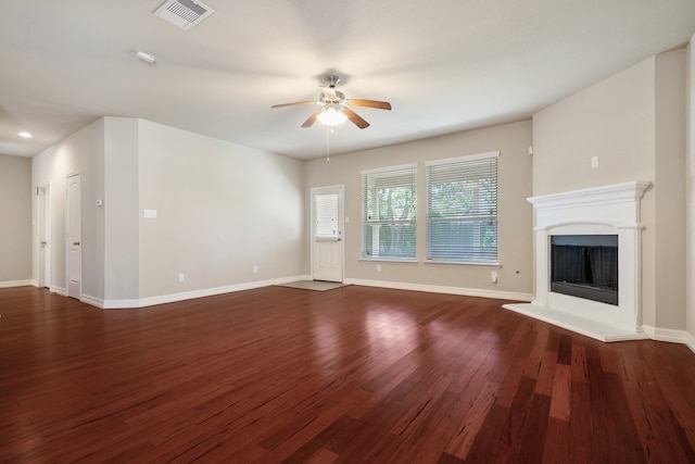 unfurnished living room featuring dark wood-type flooring and ceiling fan