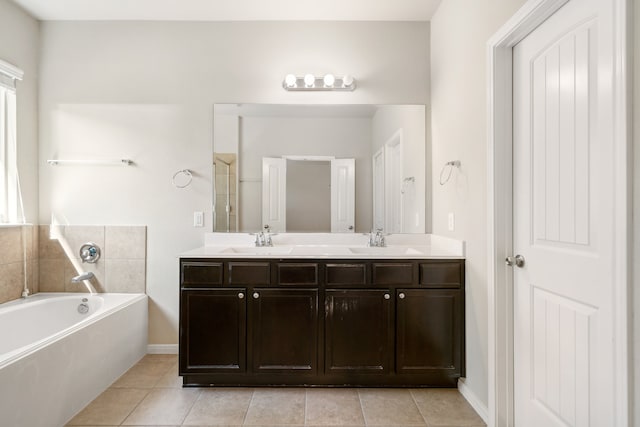 bathroom featuring vanity, a washtub, and tile patterned flooring