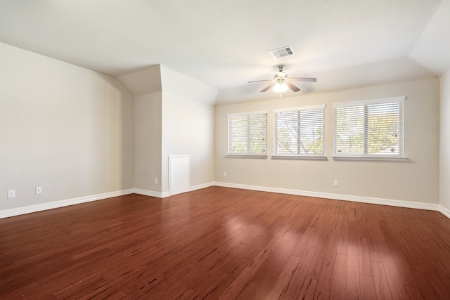 spare room with ceiling fan, a healthy amount of sunlight, vaulted ceiling, and dark hardwood / wood-style floors