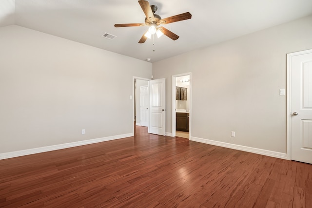 unfurnished bedroom with connected bathroom, ceiling fan, vaulted ceiling, and dark hardwood / wood-style floors