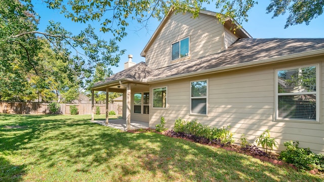 back of house featuring a patio and a yard