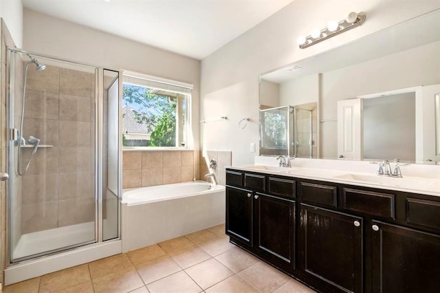 full bath featuring a garden tub, a shower stall, a sink, and tile patterned floors