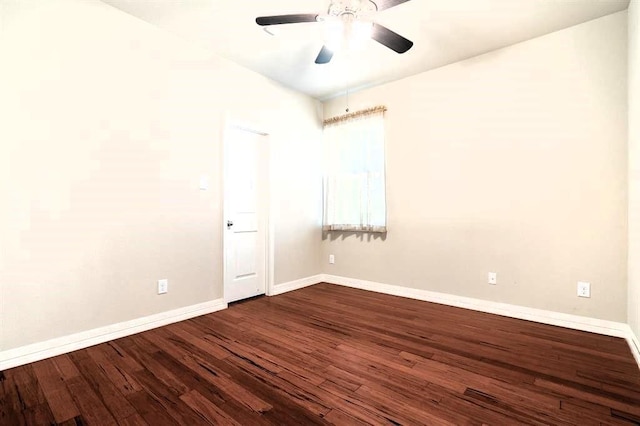 spare room with a ceiling fan, dark wood-style flooring, and baseboards