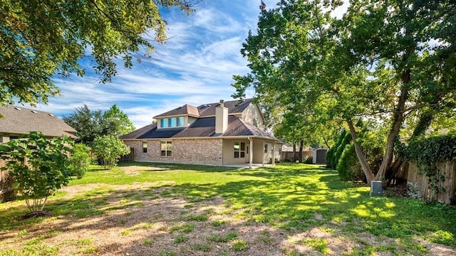 back of property featuring a fenced backyard and a lawn