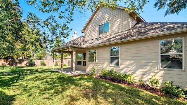 back of house featuring a patio area, fence, and a yard